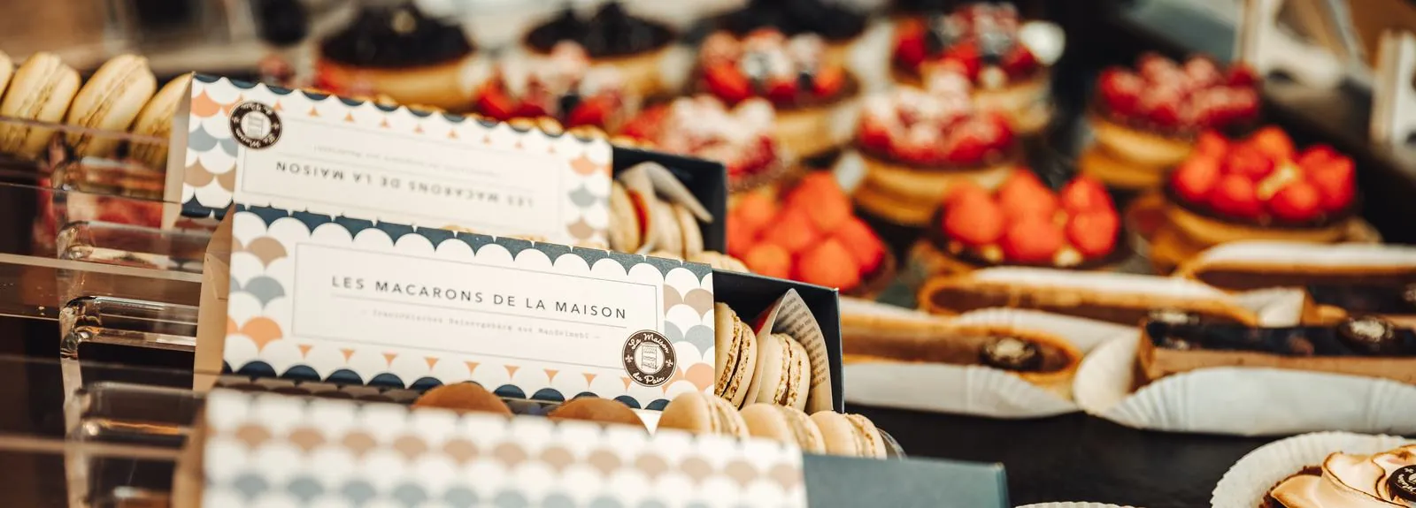 Vitrine mit Macarons de la Maison, Tartes und Éclairs